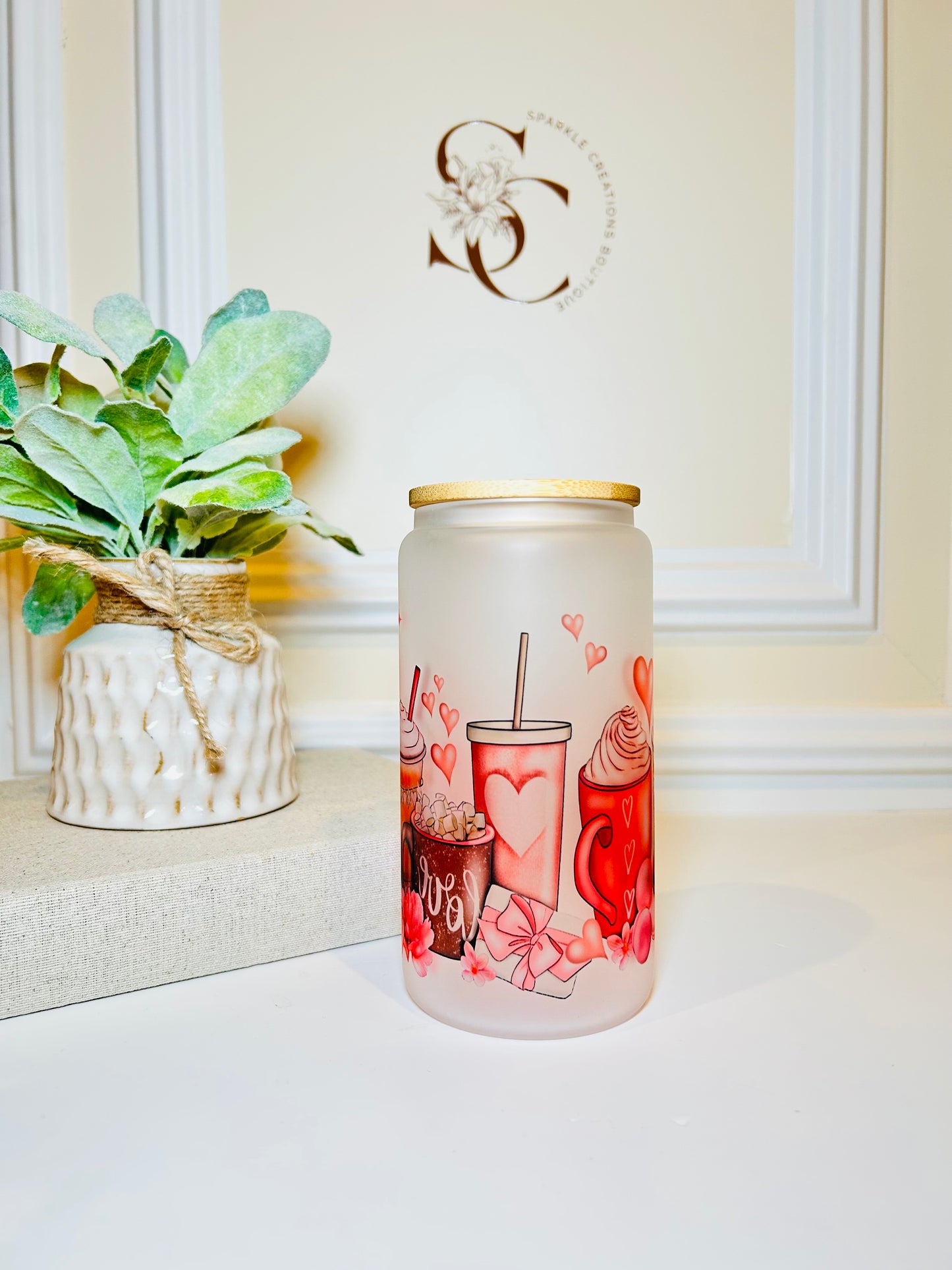 Decorative glass jar with illustrations on a white surface